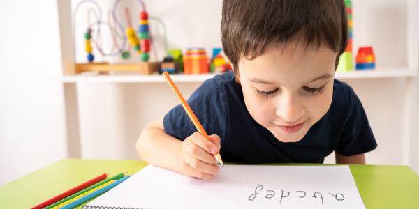 Enfant qui apprend à former ses lettres